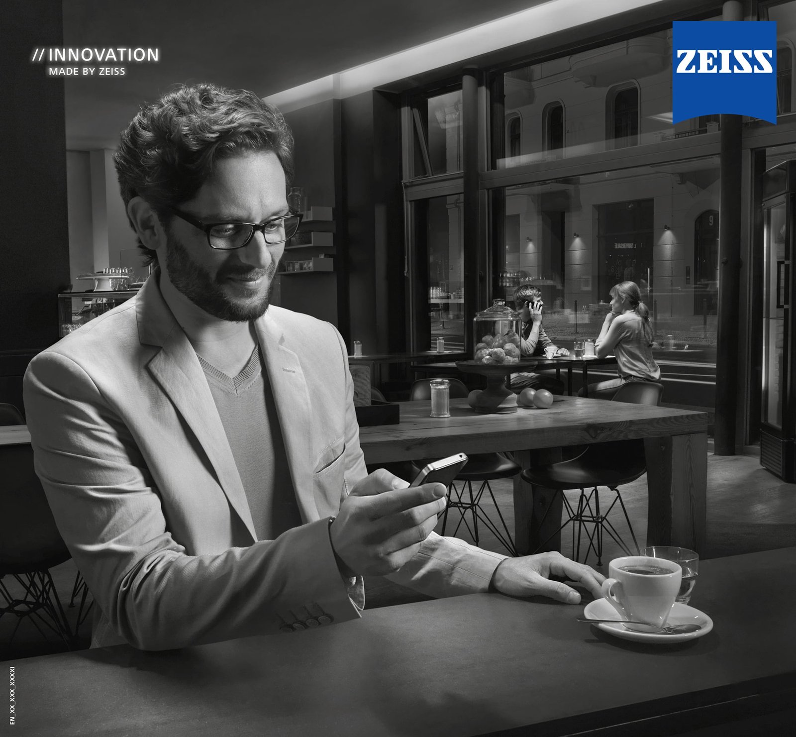 Image of person on his phone wearing glasses