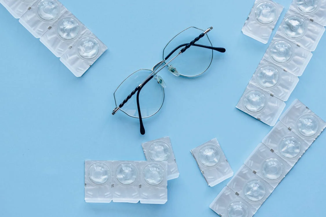 contact lenses and glasses on blue background
